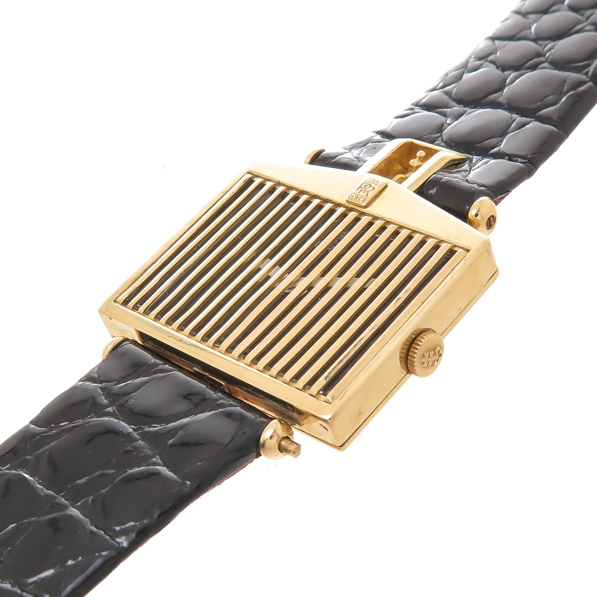 Circa 1980 Corum Rolls-Royce Wrist Watch:: 33 X 29 MM 18K Yellow Gold Case:: ayant une grille d'or sur le cristal qui protège le cadran noir avec des aiguilles blanches. mécanique 17 rubis:: vent manuel Mouvement. Bracelet noir texturé d'origine