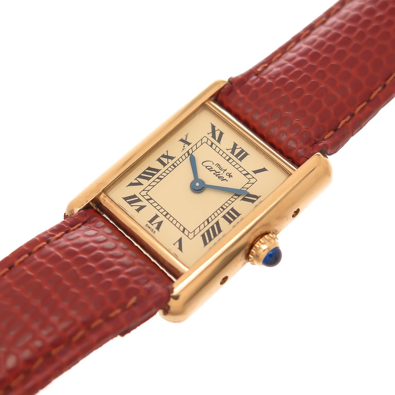 Circa 2000  Cartier mid size Tank Watch, Vermeil, Gold plate on Sterling Silver  case measuring 28MM  X  21MM, Quartz movement, light cream Dial with Black Roman Numerals, Sapphire Crown, New Brown Hadley Roma Lizard Strap and Original Gold Plate