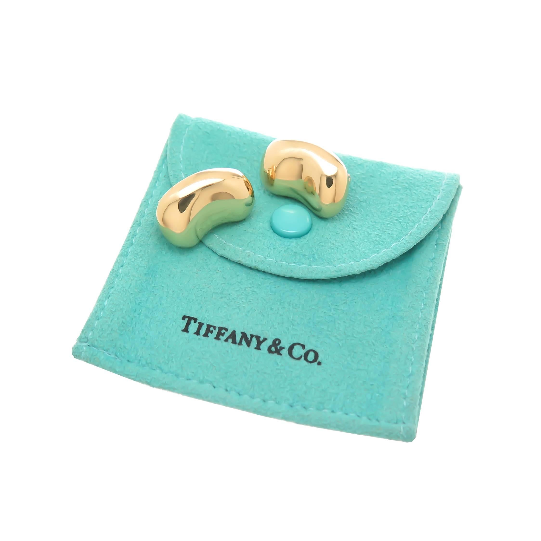 Circa 1990 Elsa Peretti for Tiffany & Company 18K Yellow Gold Classic Bean Earrings, measuring 3/4 inch in length and 1/2 inch wide and weighing 14.5 grams. Omega clip backs with a post. Accompanied by a Tiffany Suede Gift Pouch