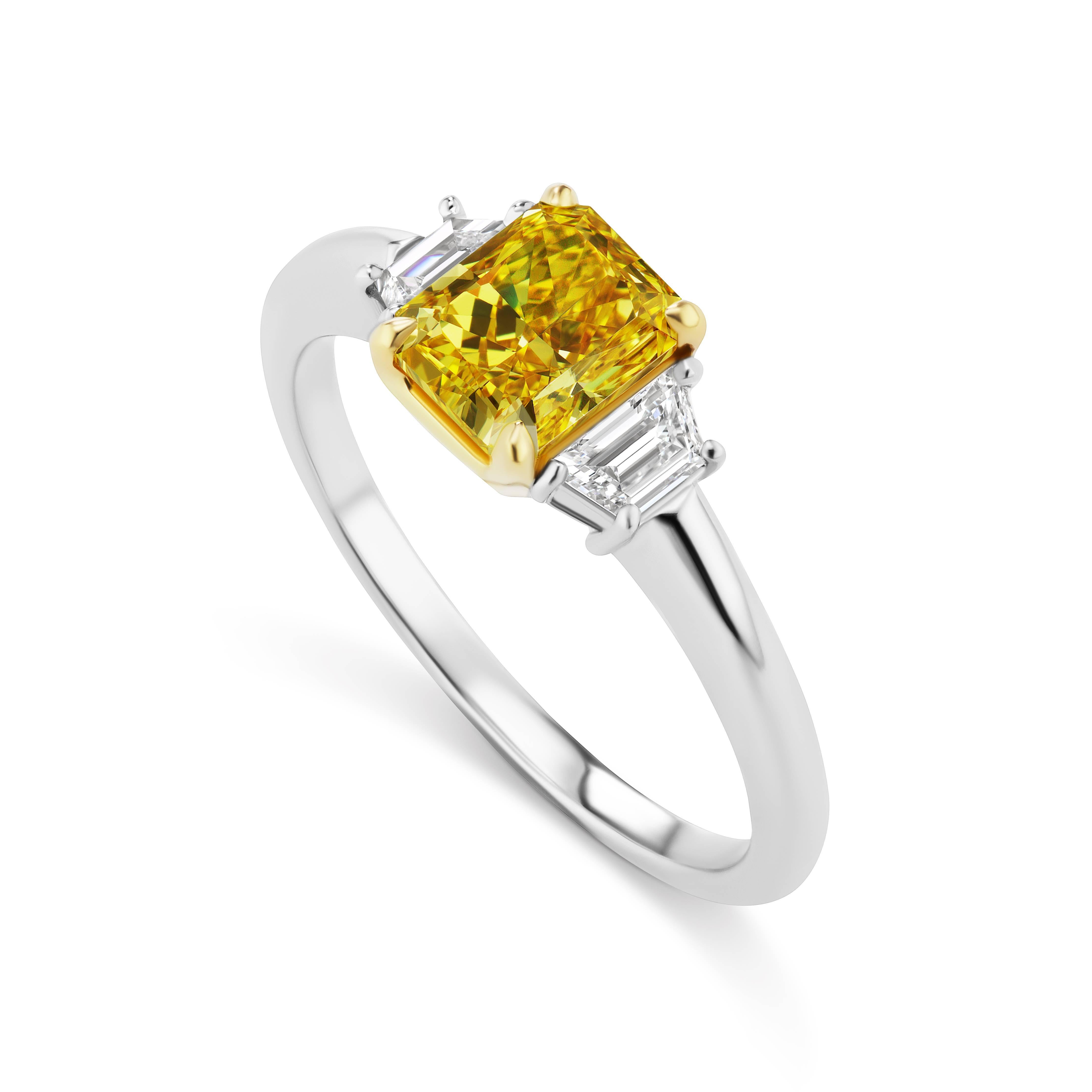 From the Collection of Scarselli, this 1.18 carat Fancy Vivid Yellow VS2  Radiant cut diamond is mounted with .25 total carats of side Trapezoid shape diamonds in Platinum and 18 karat Yellow Gold.  

The ring is sizeable.  This Scarselli Classic