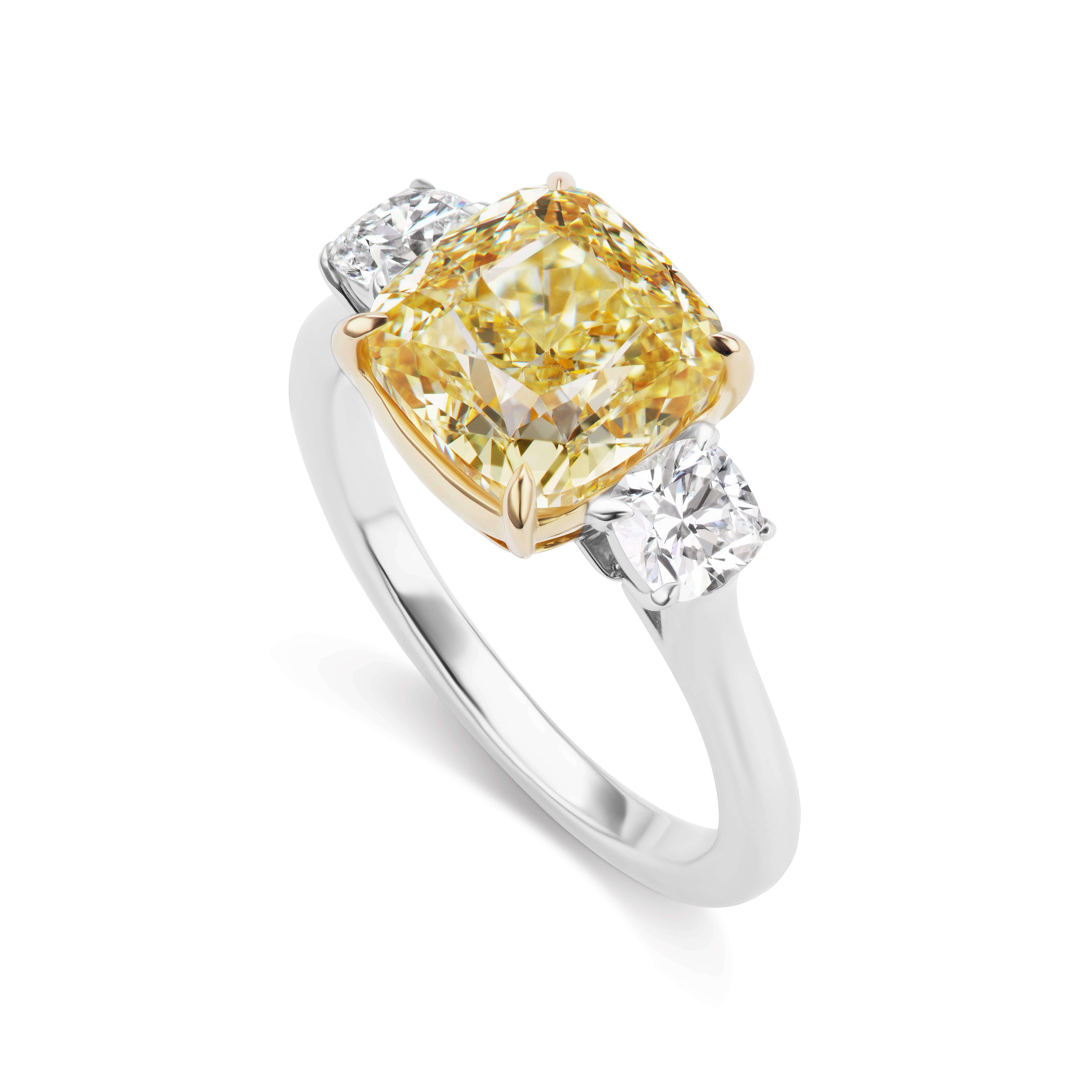 2018 is the Year of the Three Stone Cushion Cut Engagement Ring  and this ring is perfection with a 3.74 carat Fancy Yellow Cushion Cut Diamond of  VS2 clarity, GIA Certified,  with .58 carats in white side Cushion cut diamonds in Platinum and 18