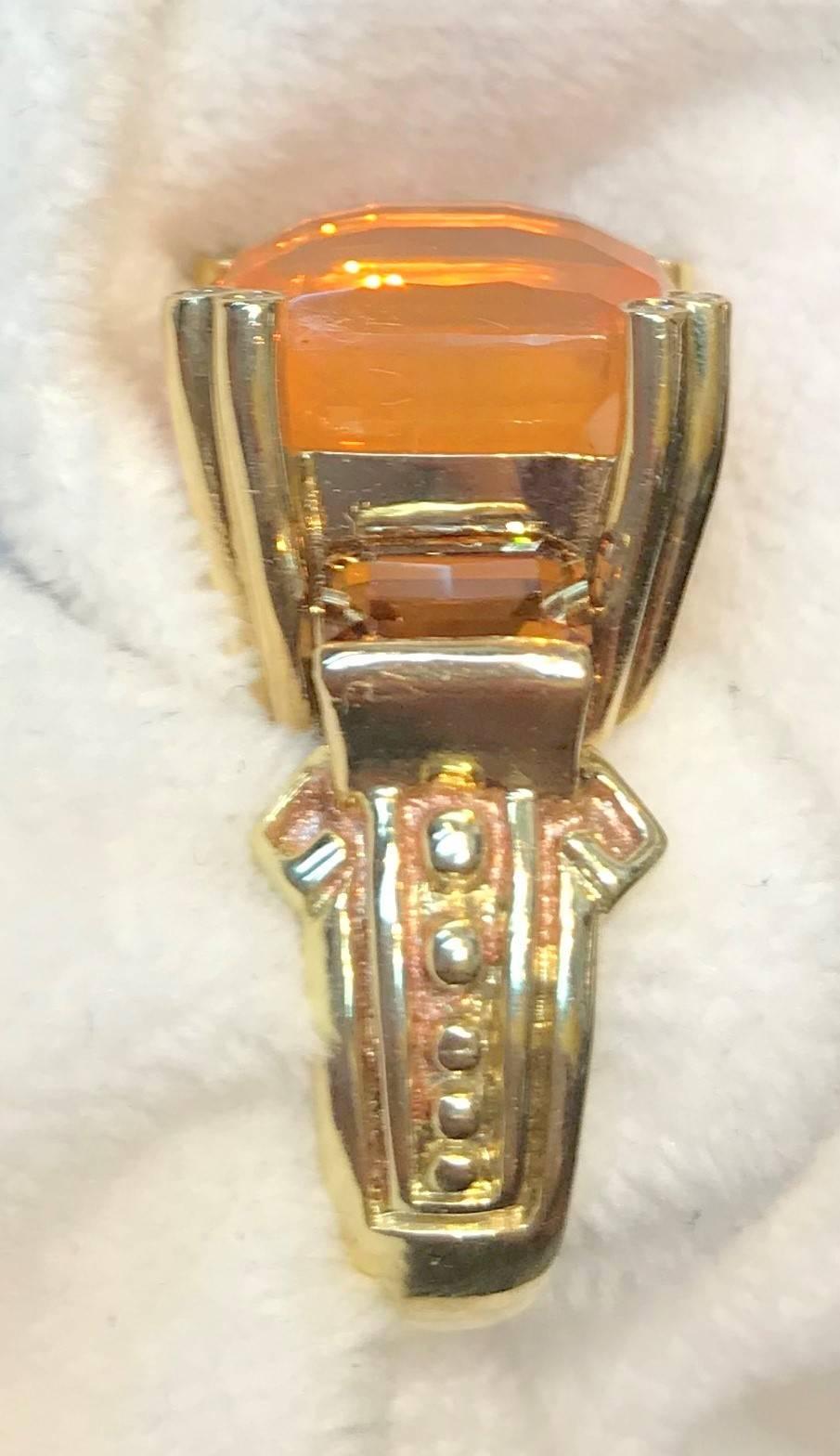A beautiful checkerboard cushion cut Mexican Fire Opal over 8cts set with .04cts diamond prongs with 3.26cts of natural cognac zircons on the side all set on a handmade,  18K yellow gold byzantine style shank.  