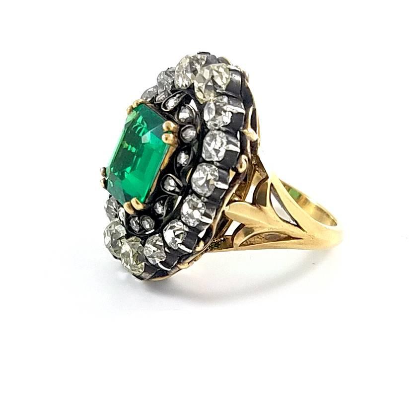 A beautiful handmade ring centered with a 2.10 carat natural, no oil square-shape emerald from Colombia accented with a cluster of 32 old-mine cut diamonds, weighing approximately 2 carats.
The ring is handmade in 18k yellow gold size 6 US. 
The