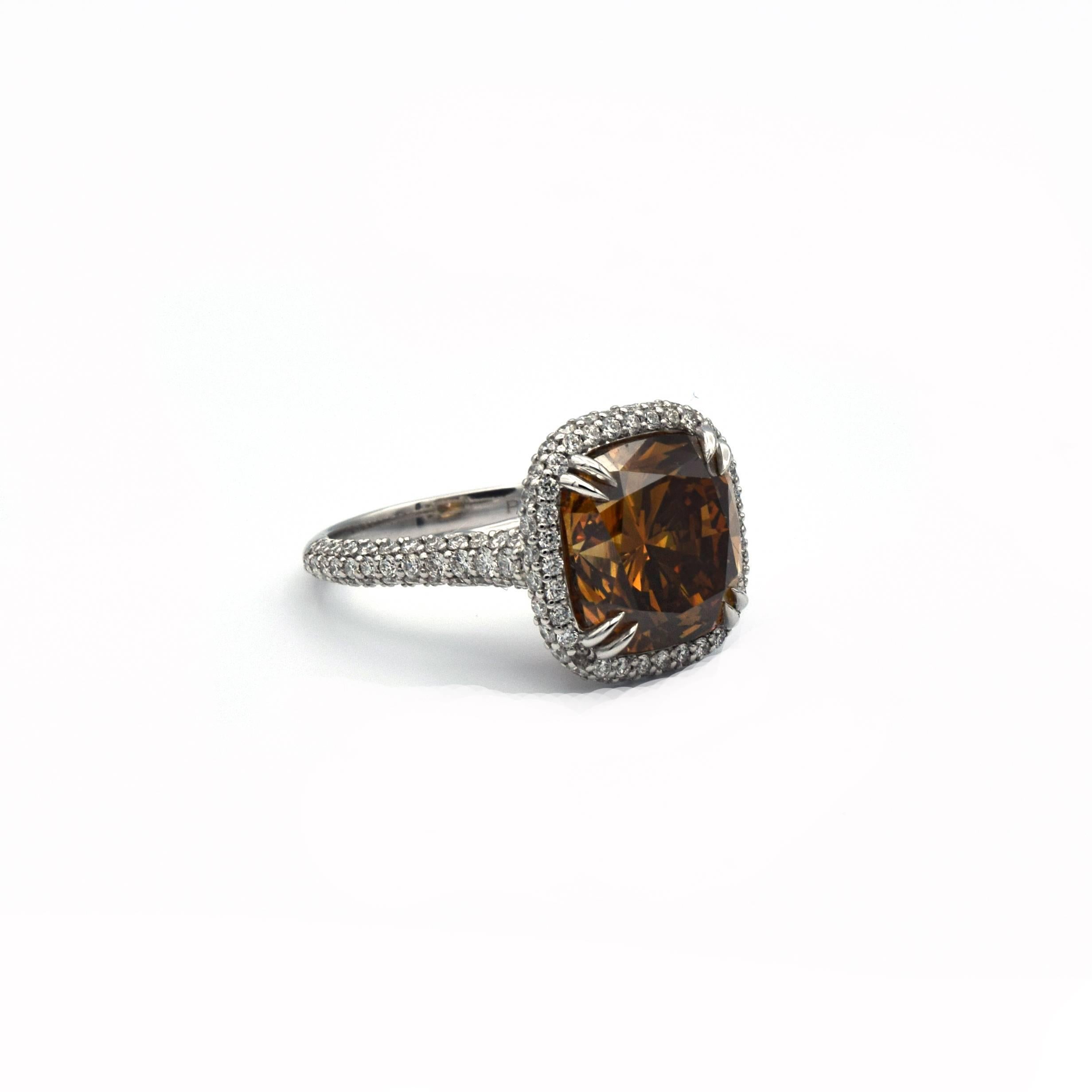 This beautiful Natural Fancy Color Diamond is set in a handmade Platinum Ring.
The center diamond is a 6.88 carat Fancy Deep Brown Orange VS2 (GIA Certificate Number 2125937409).
Surrounding the center stone approximately 1.12 carats of white