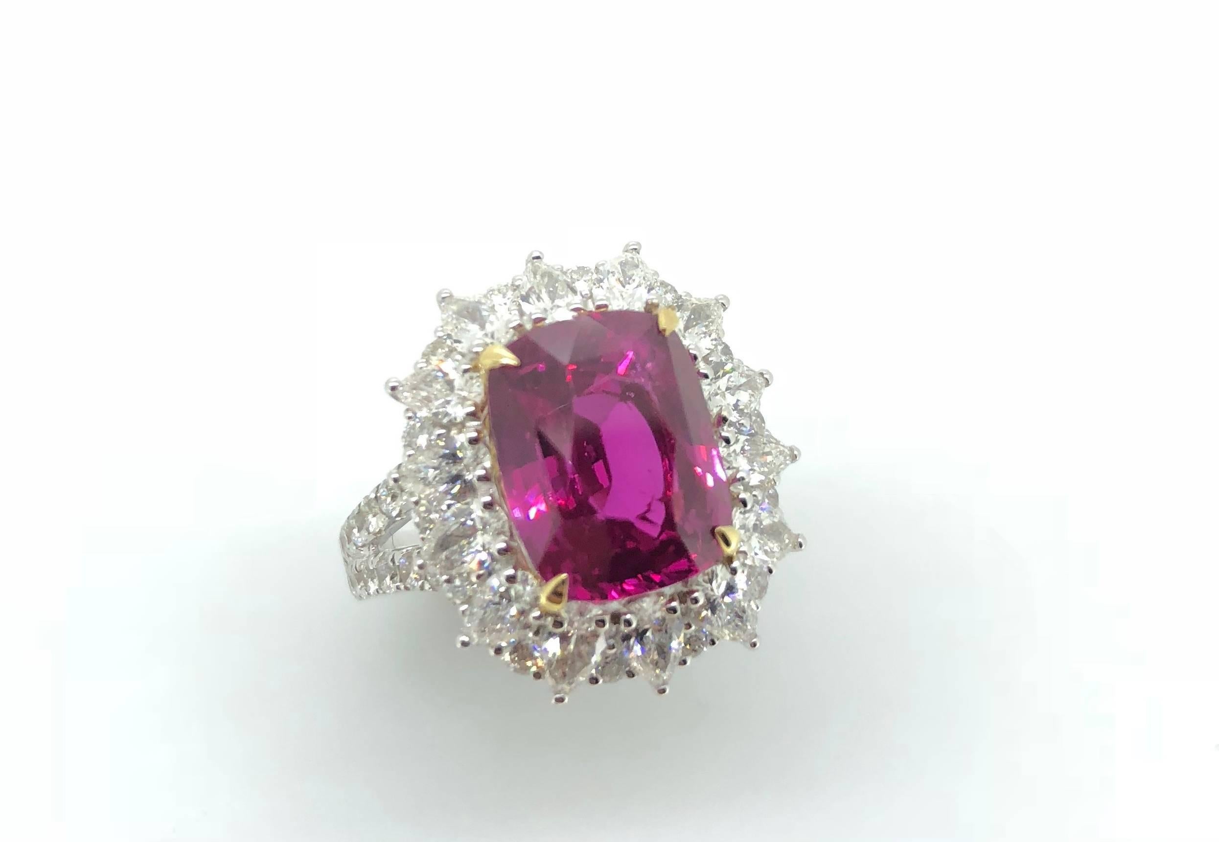 A 7.00 Carat Cushion cut Vivid Pink Sapphire (Heat) Cocktail Cluster Diamond Ring. 

Mounted in 18K White and Yellow gold with cluster of pear shape diamonds interspaced by round brilliant cut diamonds. The ring is ornately completed with a diamond