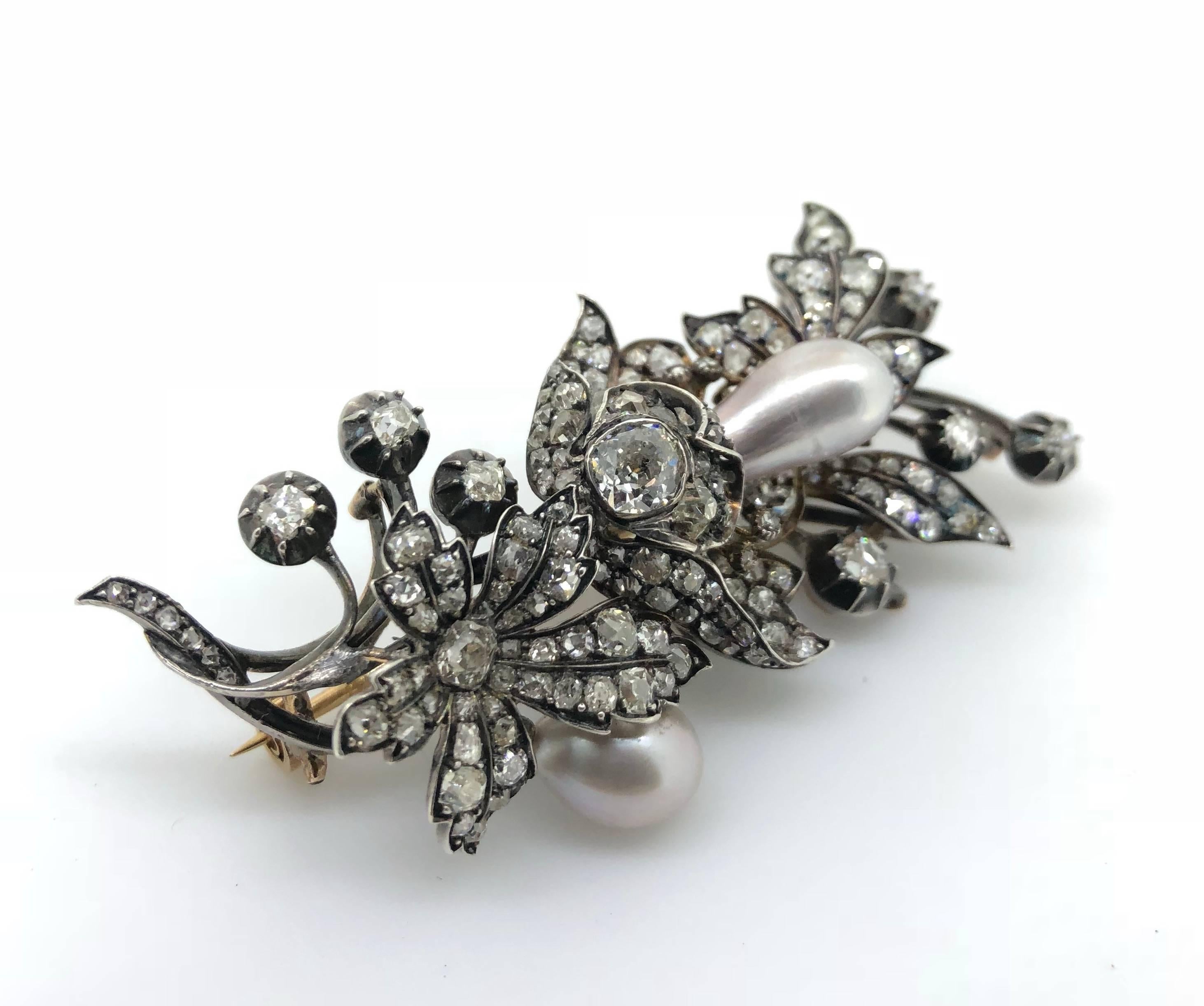 A natural pearl and diamond spray brooch, circa 1860
Of floral and foliate design, set with two drop-shaped natural pearls of grey tint, within a similarly-cut diamond surround, to pinched-collet set cushion-shaped diamond buds, cushion-shaped