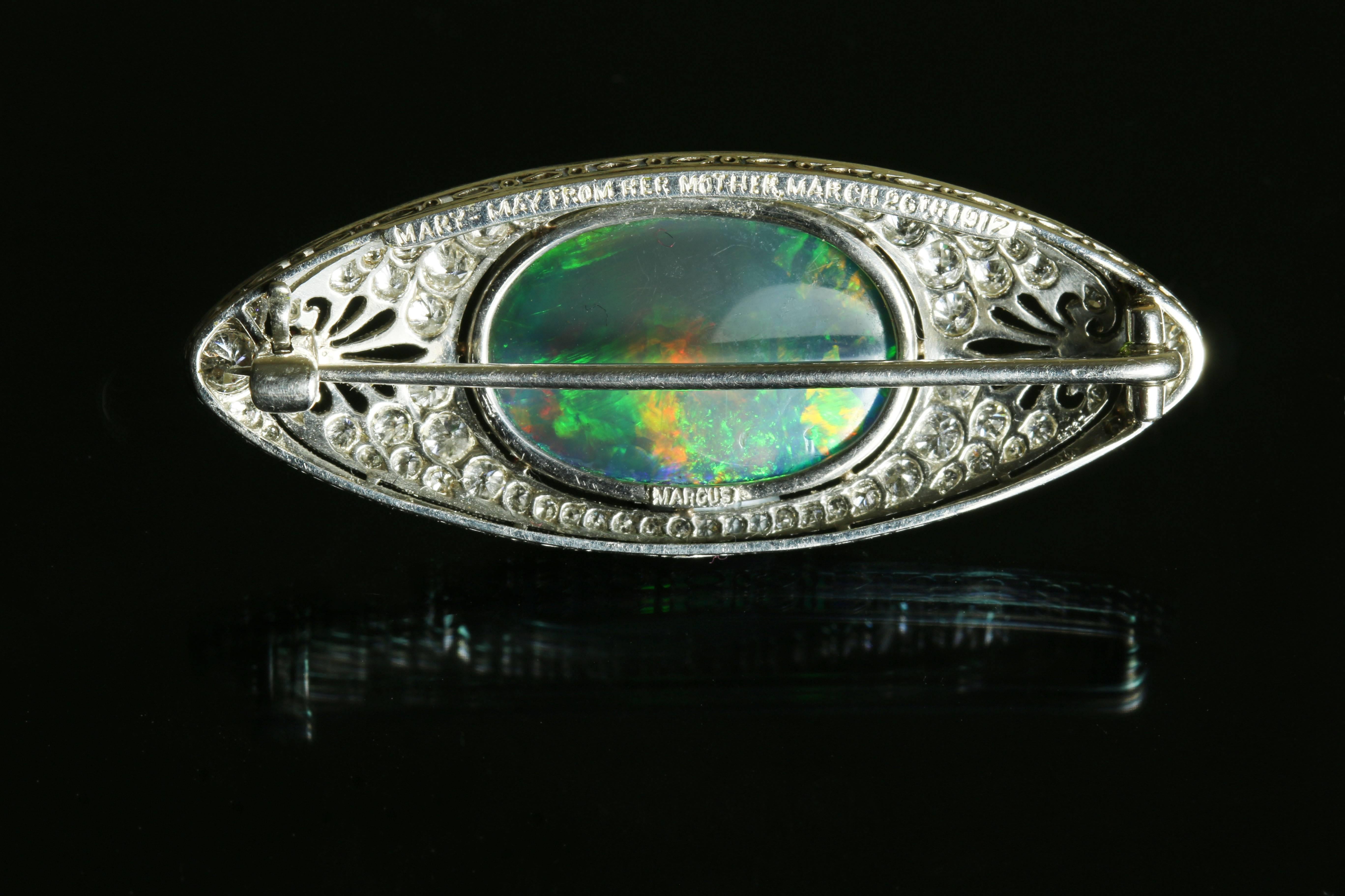 This is a stunning black opal brooch by the American maker, Marcus & Co. The black opal at the centre is truly special as stones with this even distribution of colour along with this mix of reds, greens and blues are very rare. 

The main stone