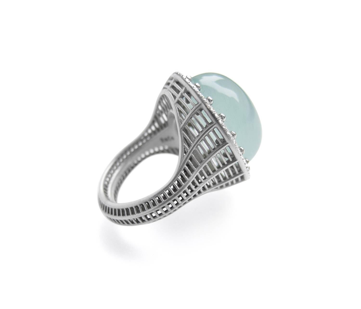 From the Wired Collection, a cocktail ring in 18k white gold with a one-of-a-kind chatoyant aquamarine cabochon (25 cts) and white diamond pavé (0.32 cts). Signature wireform grid pattern with ball prong settings. Matte finish. Size 7.