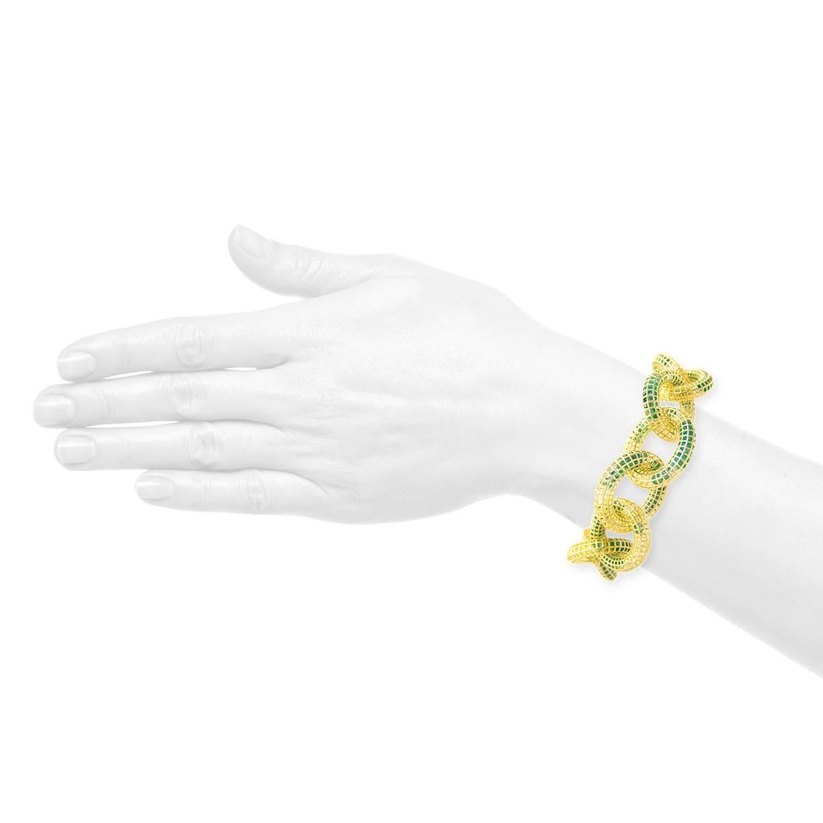 From the Wired Collection, a chainlink bracelet in 18k yellow gold with 42 cts of loose emeralds and flush-set emerald baguettes (0.41 ct). Bright satin finish with polished highlights. V-lock closure. Square grid pattern.
     Bracelet has 7-1/2”
