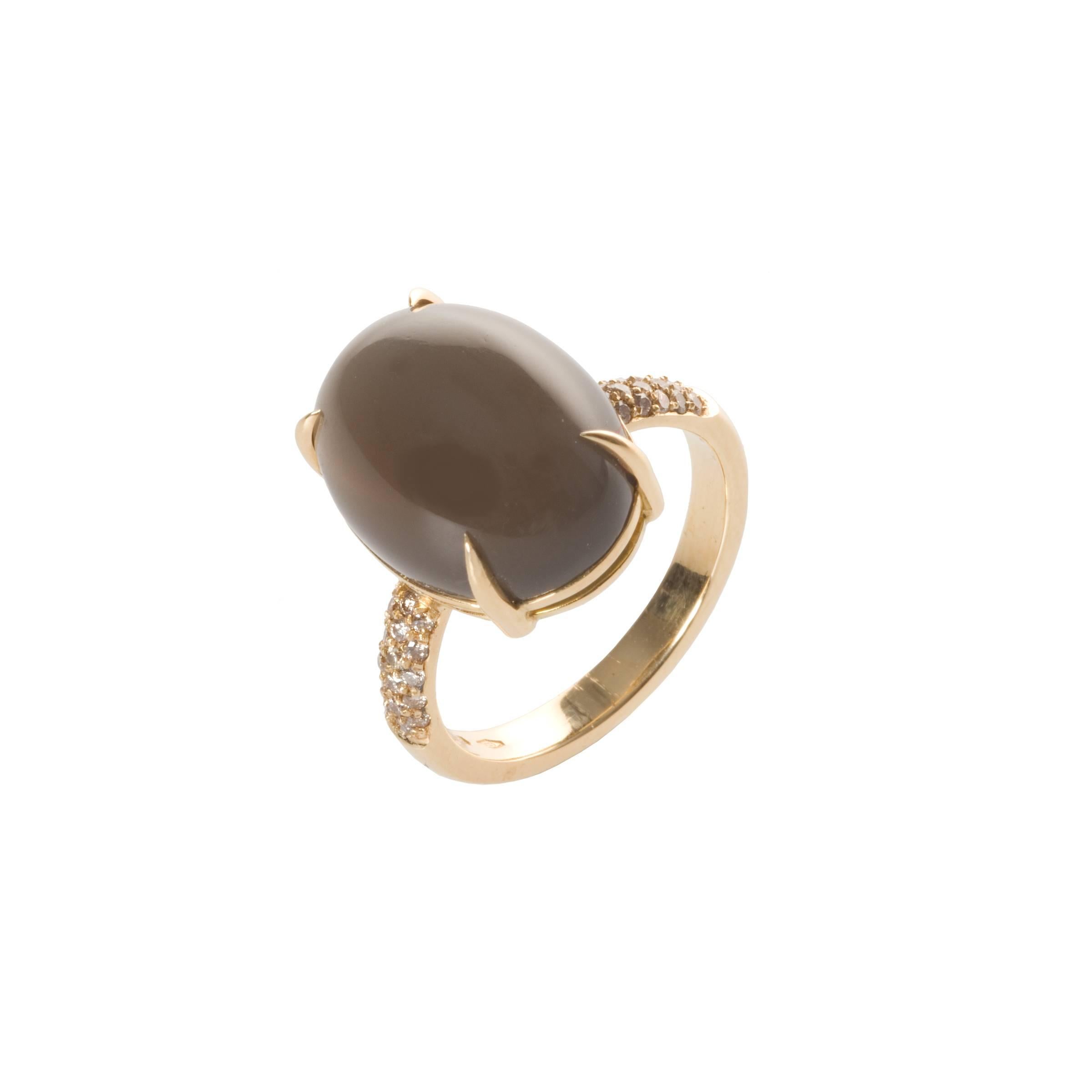 This beautiful Dark Grey Moonstone has been set in an 18kt yellow gold band with 32 pavé Fancy Champagne Diamonds. 

Handmade by a fifth generation Italian goldsmith no two pieces are the same. We pride ourselves in having hand cut the 9,72ct
