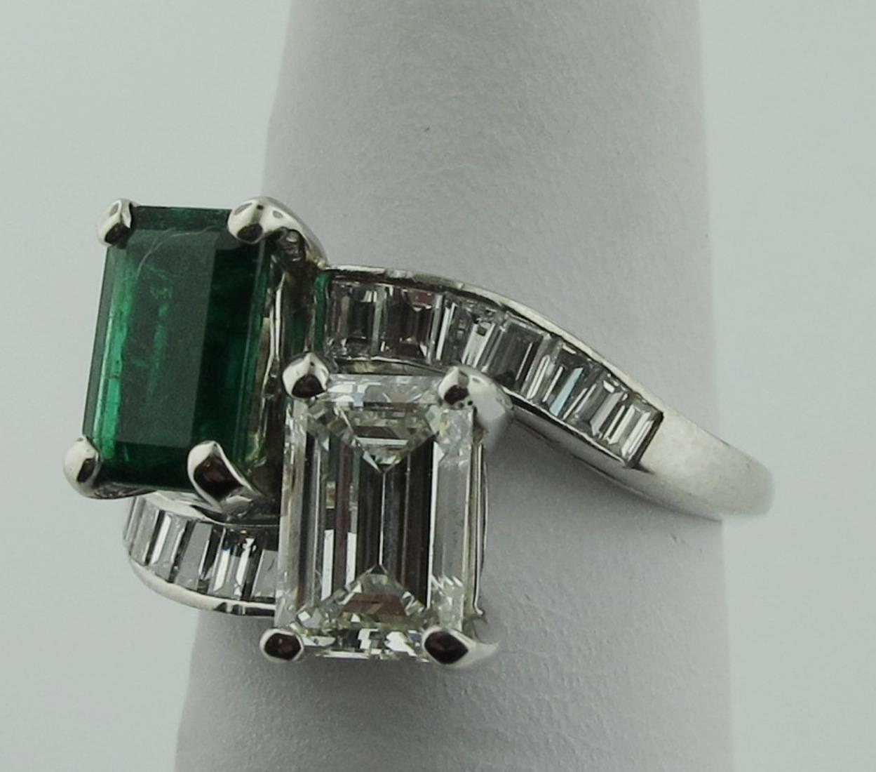 Two stone, Cross-over Emerald and Diamond ring set in platinum.  The 1.47 carat diamond is accompanied by GIA certificate #1186880170. The diamond is H color, VVS-2.  The emerald cut Emerald weighs 1.46 carats.  There are 14 baguette diamonds on the