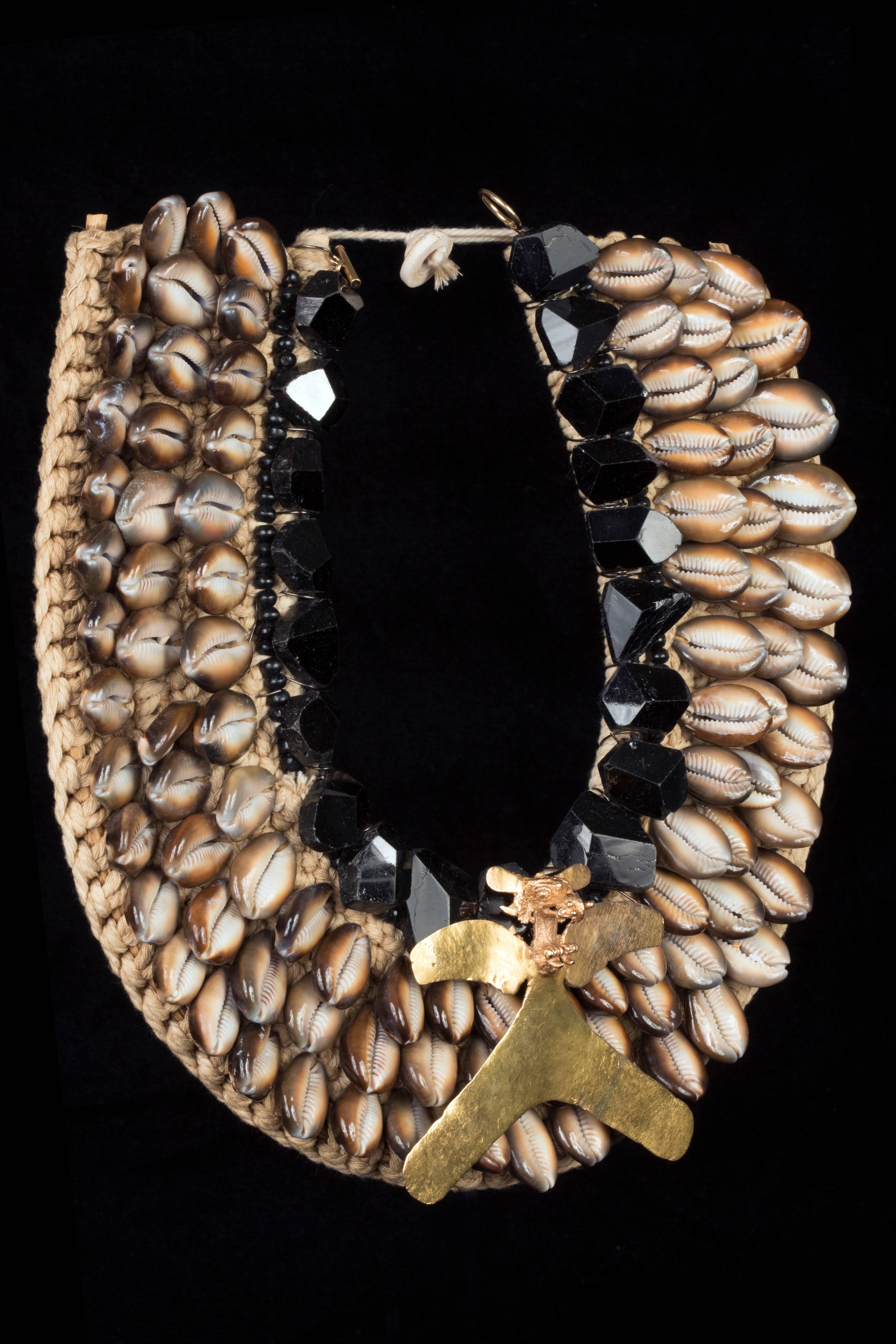 Black tourmaline drop necklace (326 gms-1630 ct.) with Veraguas gold eagle pendant with a small animal in its beak ca. 800 to 1500 AD mounted on a Coffee Bean Trivia Shell pectoral. Panama, a gold avian pendant spreading its wings and splayed tail.