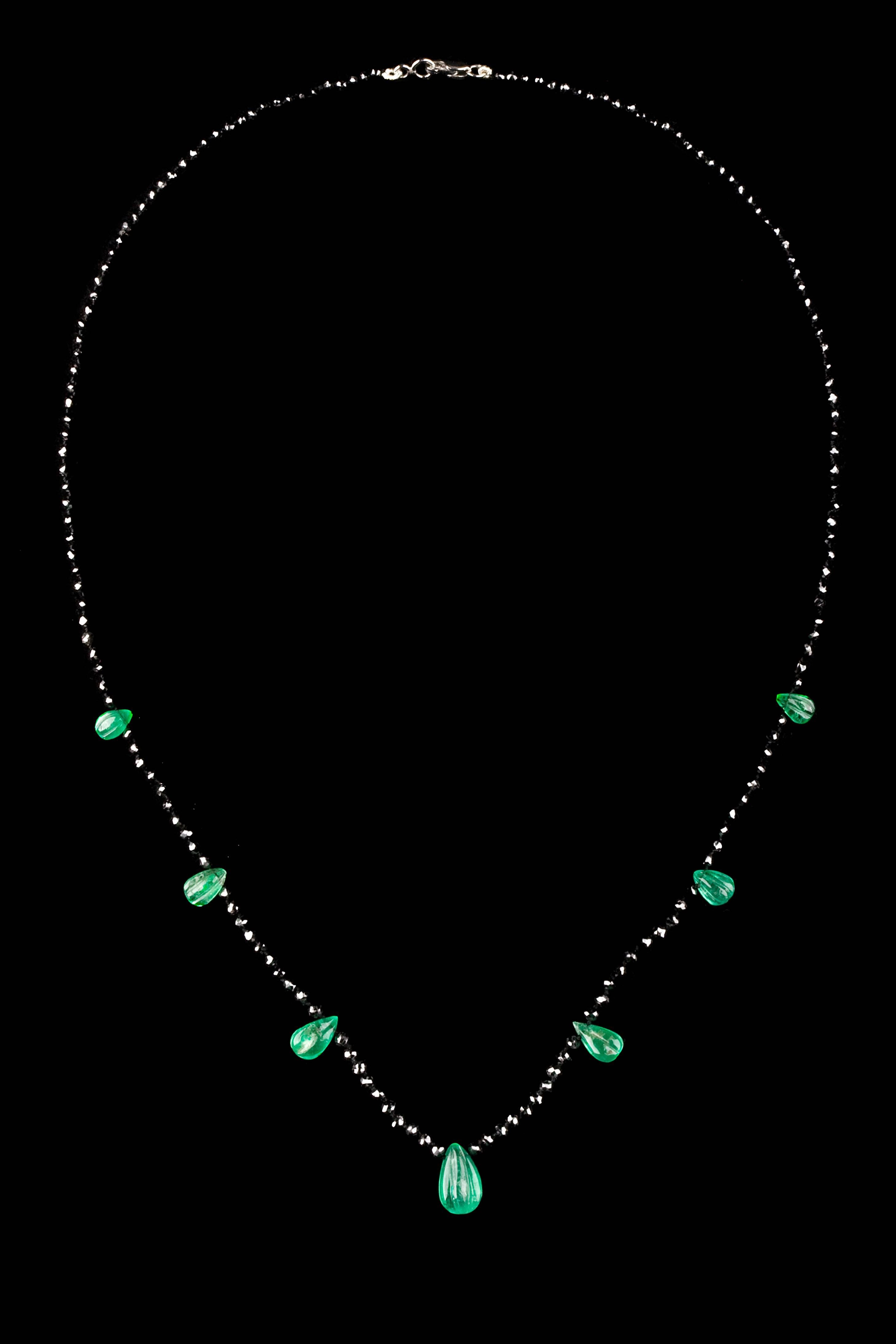 Contemporary design graduated 21.5 carat black diamond necklace and 7 gadrooned pear shaped emeralds.

