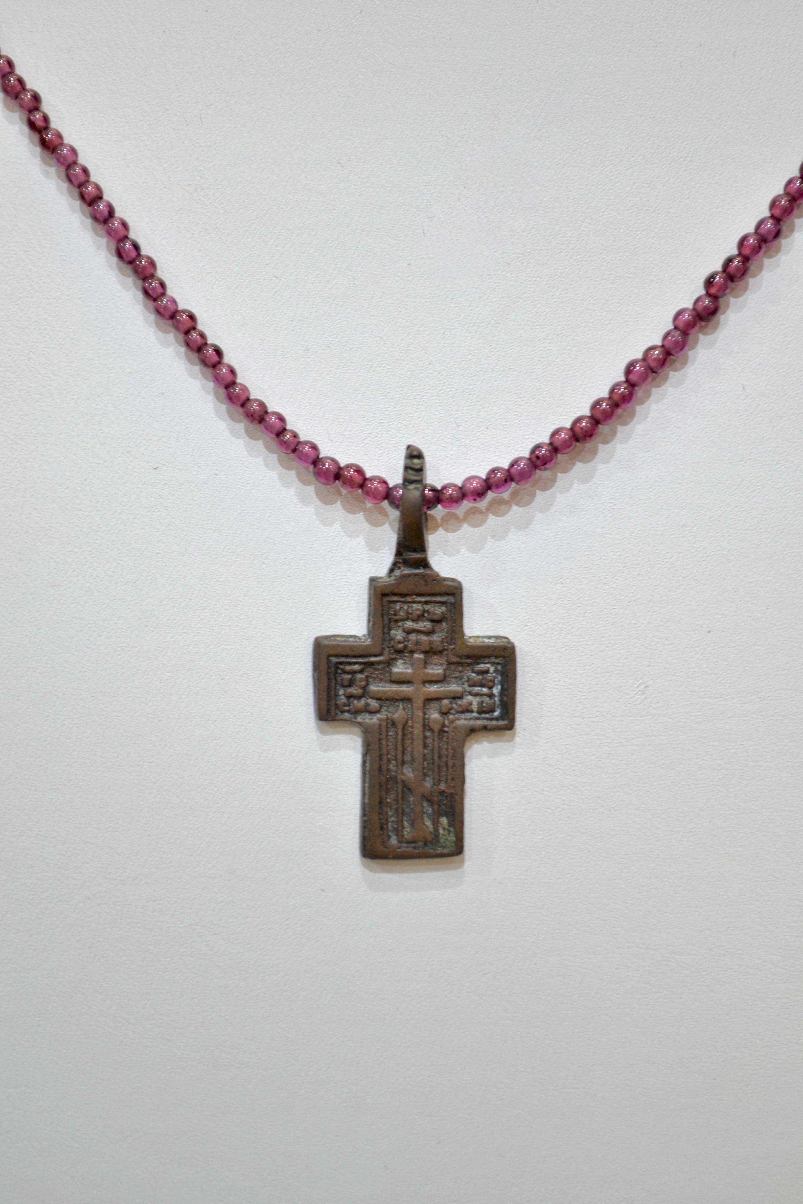 Late Medieval Bronze Cross Pendant. Professionally cleaned and polished to show original details. Obtained from an old British collection, acquired from the L.C.F. (London). Bright garnet beads necklace accompanies this piece.