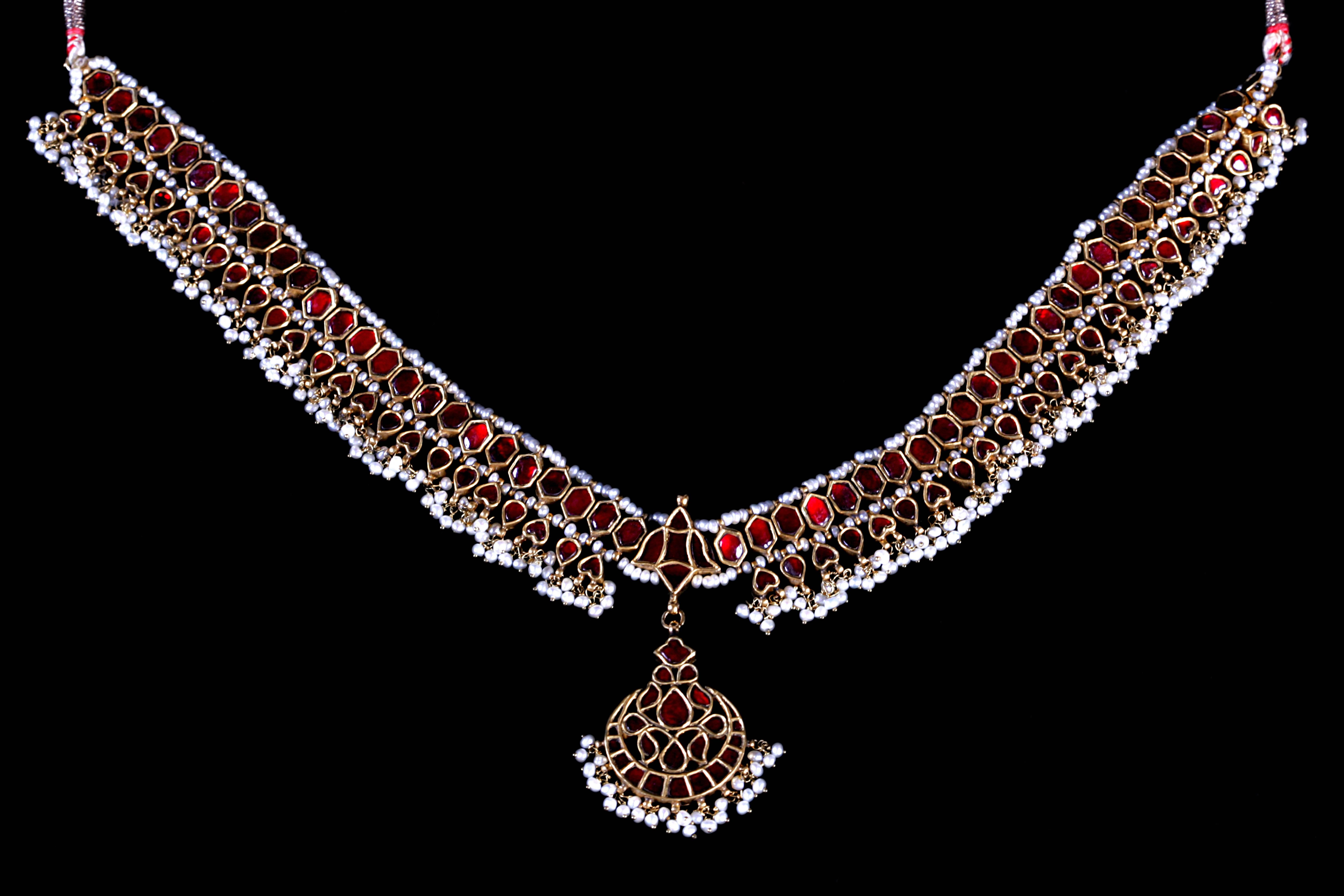 Old gold Princess necklace with rubies in one side and diamonds on the back, with hanging Basra Pearls and a Crescent Moon medallion in the center. The red rubies are chosen to commemorate the princess love to her husband, hidden from everybody's