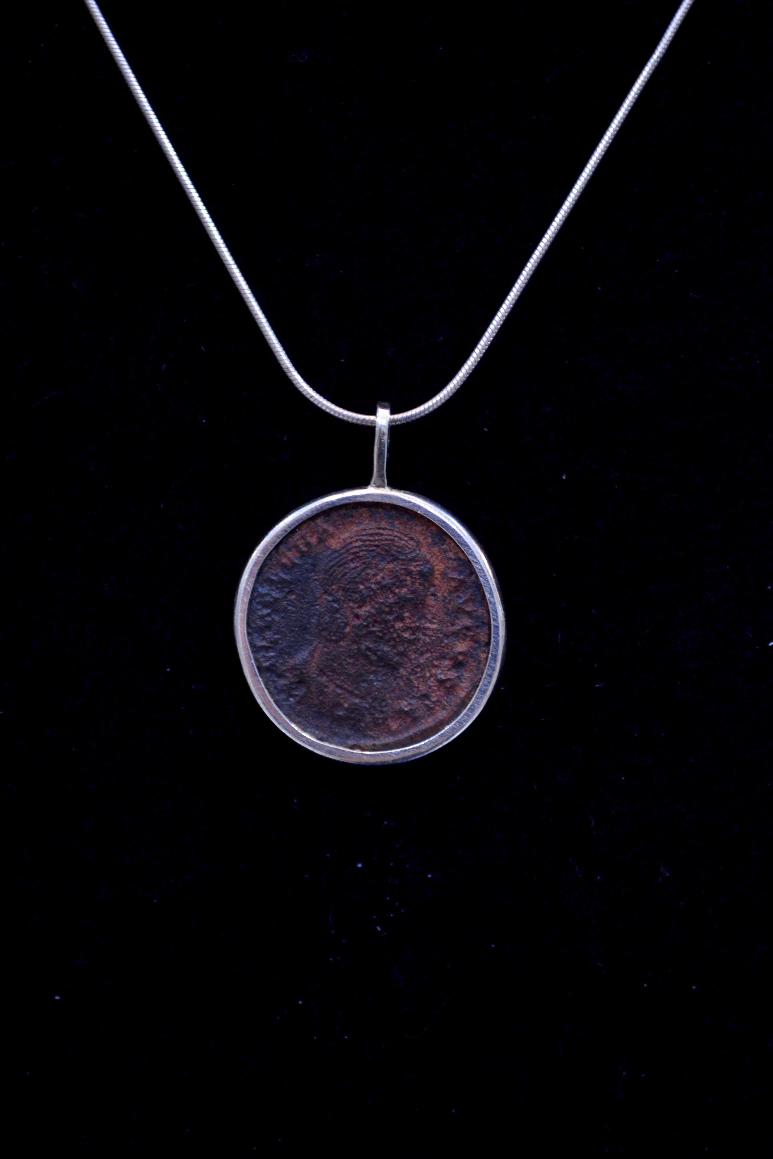 Authentic Roman bronze coin Ca. 27 BC - 476 CE mounted on contemporary silver necklace. Ready to be worn!

Bronze coin from the great Roman Empire that dates back nearly 2,000 years.  Beautiful iridescence.