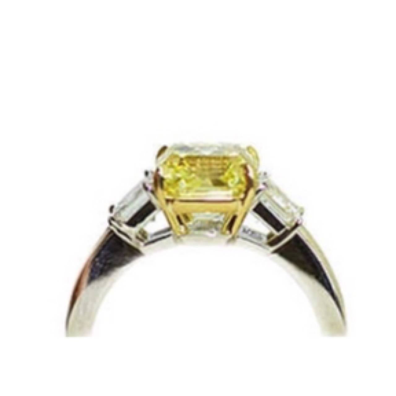 3.03ct Fancy intense yellow Asscher cut yellow diamond sits in the center of this ring. The clarity is vs1 and cut is exceptional. The center stone has a GIA certificate. 

The two white Asscher Cut diamonds are E color vs1 and total .78ct