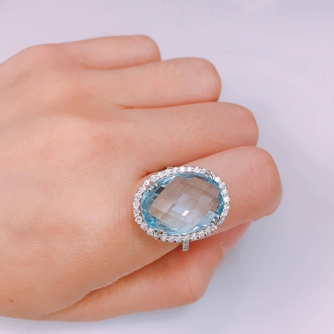 An astonishing double sided checkerboard cut Blue Topaz sits in the center of this gorgeous hand made ring. Please include your ring size in the order. 
Approx total weight: 8.10 cts
Diamond Color: E-F
Diamond Clarity: Si 
Cut: Excellent 
As noted