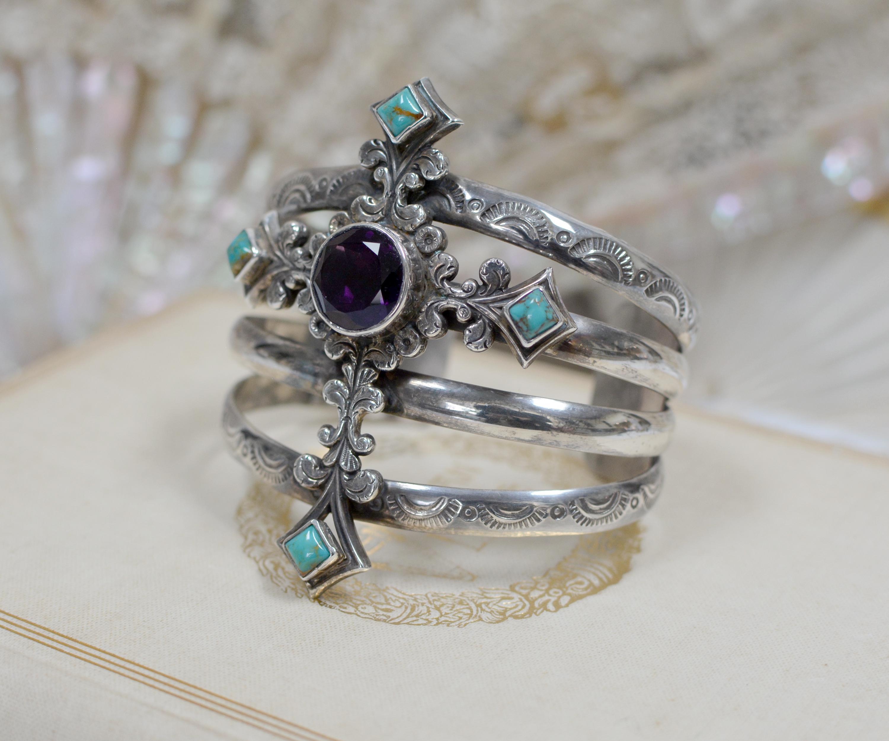 This romantic sterling silver cuff bracelet by designer Jill Garber is exquisitely crafted to feature an ornate figural Art Nouveau cross. At its center is a 14 mm deep purple natural Amethyst. The four tips of the cross are hand set with 6 mm