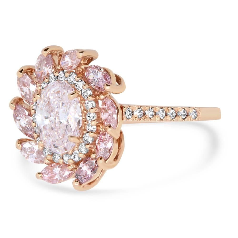 Material: 14k Rose Gold 
Center Diamond Details: 1.02 Carat Natural Fancy Pink Oval Shaped Pink Diamond measuring 7.71 x 5.39 mm - VS2 Quality

Mounting Diamond Details: 
10 Pink Round Diamonds Approximately 0.84 Carats - SI Quality 
34 Round