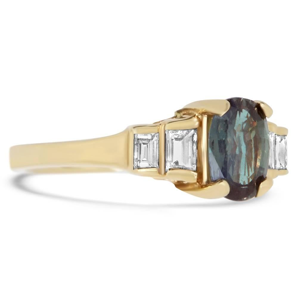 Material: 14k Yellow Gold 
Center Diamond Details: 1.01 Carat Natural Color Changing Alexandrite measuring 7 x 5 mm
Mounting Diamond Details: 4 Baguette Diamonds Approximately 0.34 Carats - Clarity: VS / Color: H-I
Ring Size: Size 5. Alberto offers
