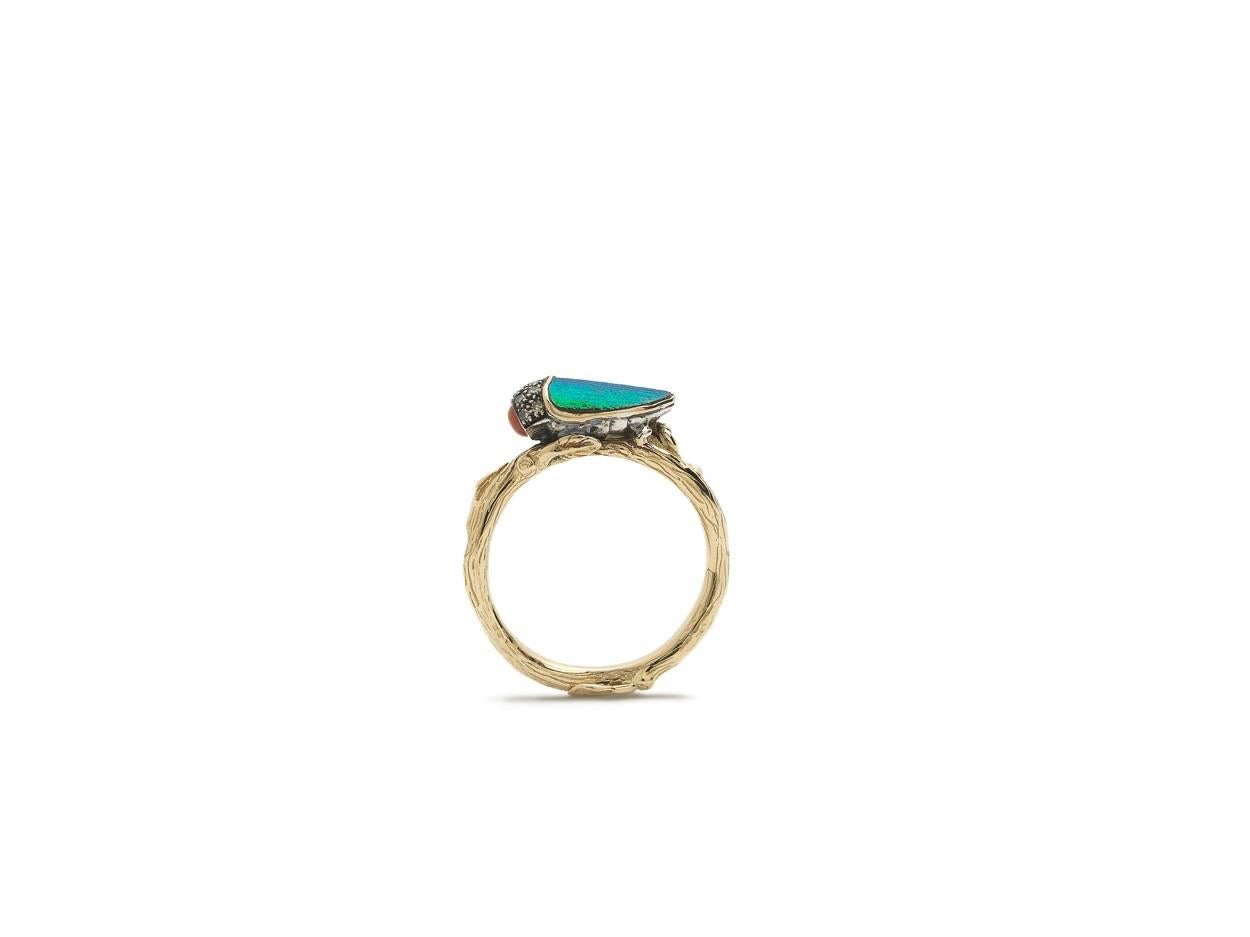 The Coral Scarab Stackable Ring is made of 18k Yellow Gold and Sterling Silver, set with naturally iridescent scarab beetle wings, brown diamonds and an orange coral nose. This ring is from Bibi van der Velden's iconic Scarab Collection, and is