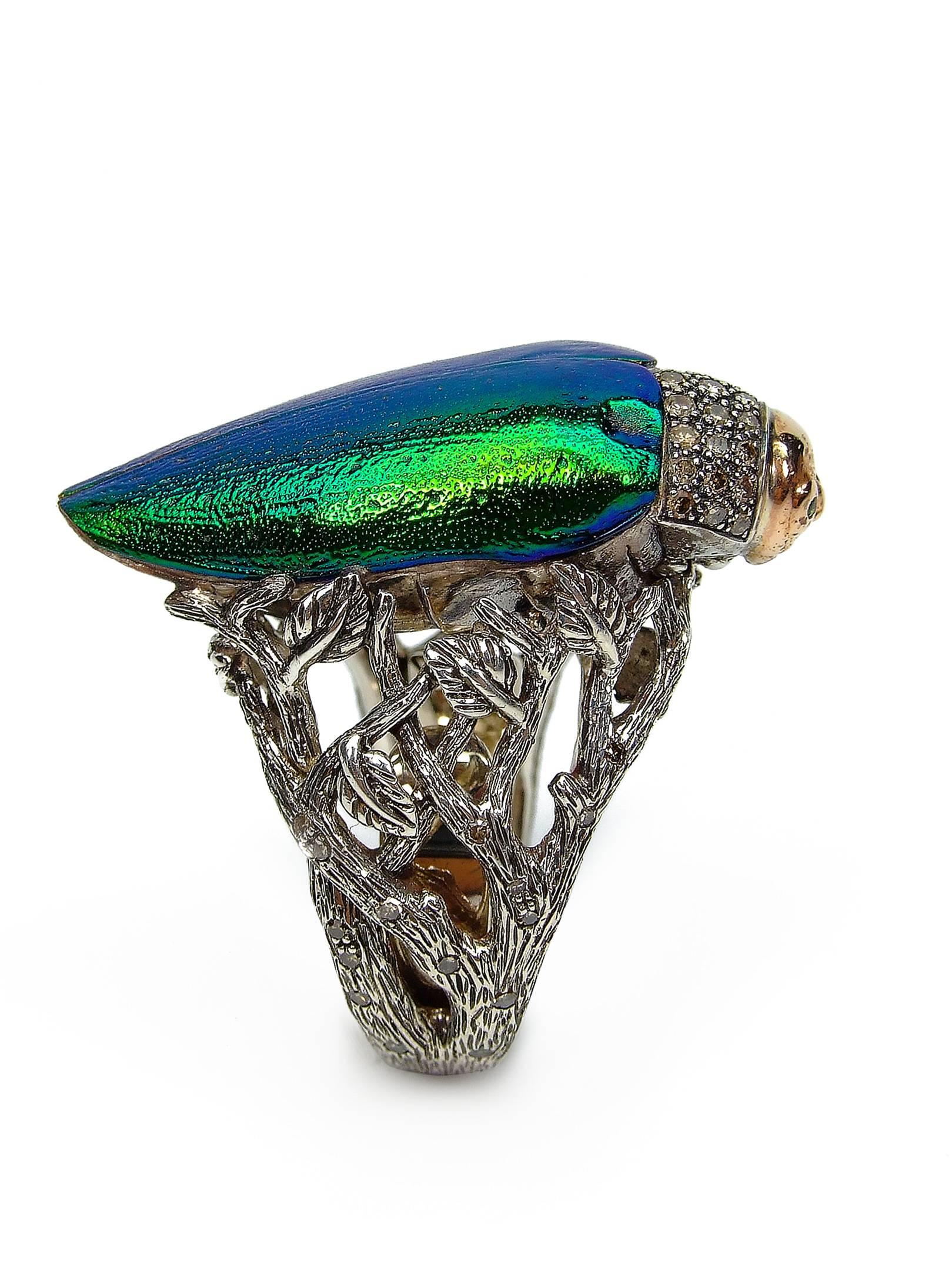 The Scarab Ring by Bibi van der Velden, from her signature Scarab collection, features completely natural recycled scarab beetle wings, set in diamond-set sterling silver and solid 18k rose gold. The beetle even includes green Tsavorite eyes. The