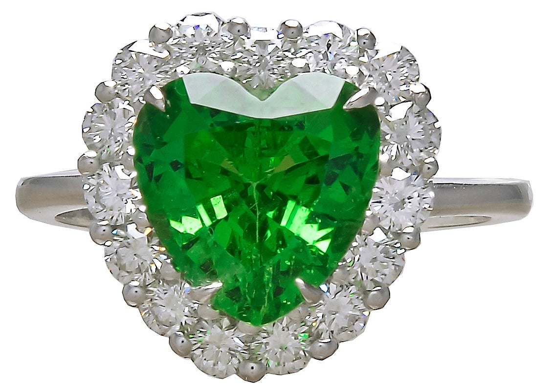 Figural heart shaped ring. Brilliant faceted tsavorite center stone, 3 cts, surrounded by very white full-cut diamonds. Set in platinum.

Size 6 and can easily be re-sized.

Absolutely gorgeous.