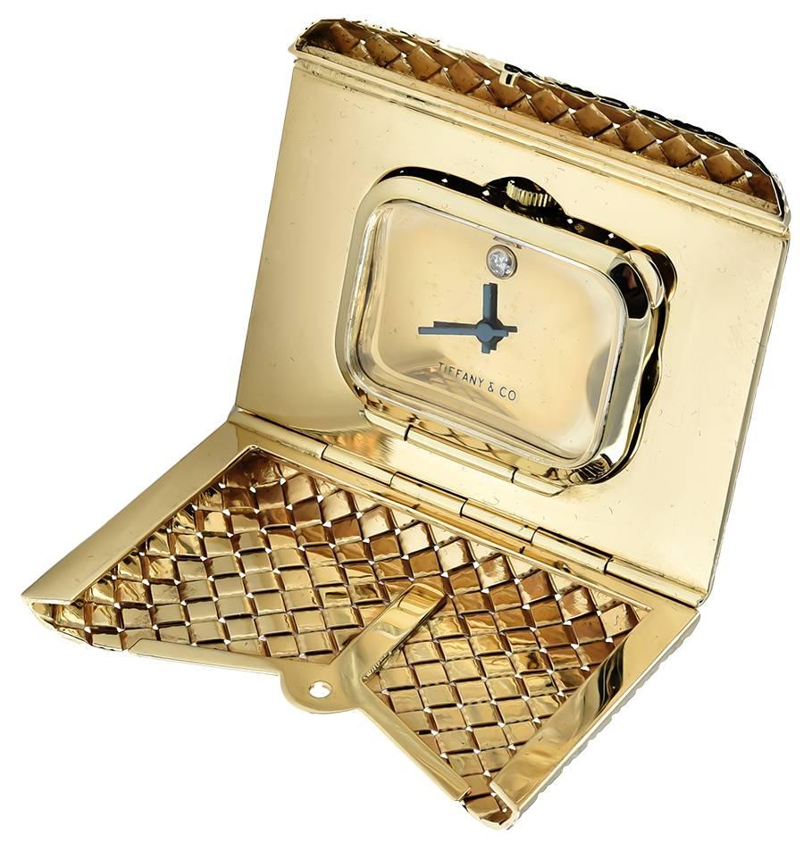 Soft, supple 14K yellow gold basket weave envelope that springs open to reveal a miniature travel clock.  Made and signed by TIFFANY & CO.  Mechanical movement, set with a diamond at midnight.  1 3/4