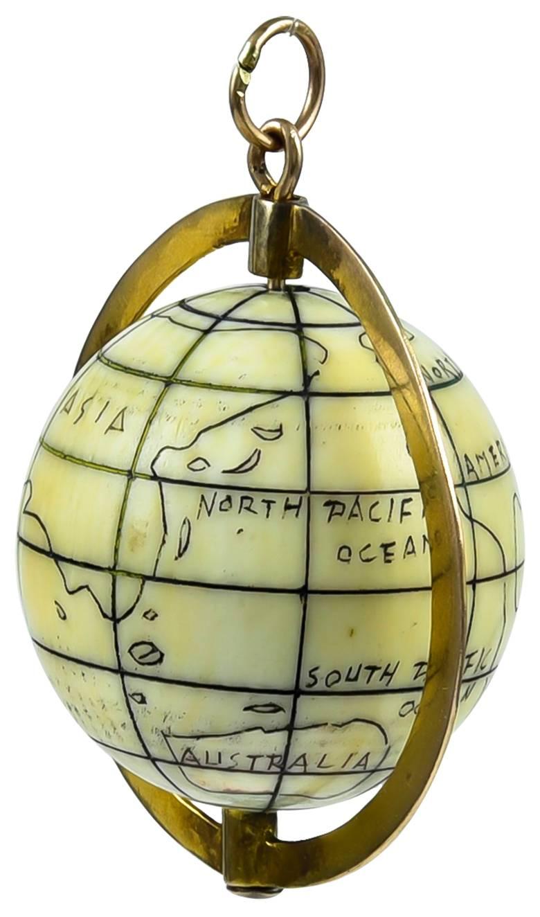 Large globe charm.  Spinning decorated bakelite globe, set in a 14K yellow gold holder.  1 1/4