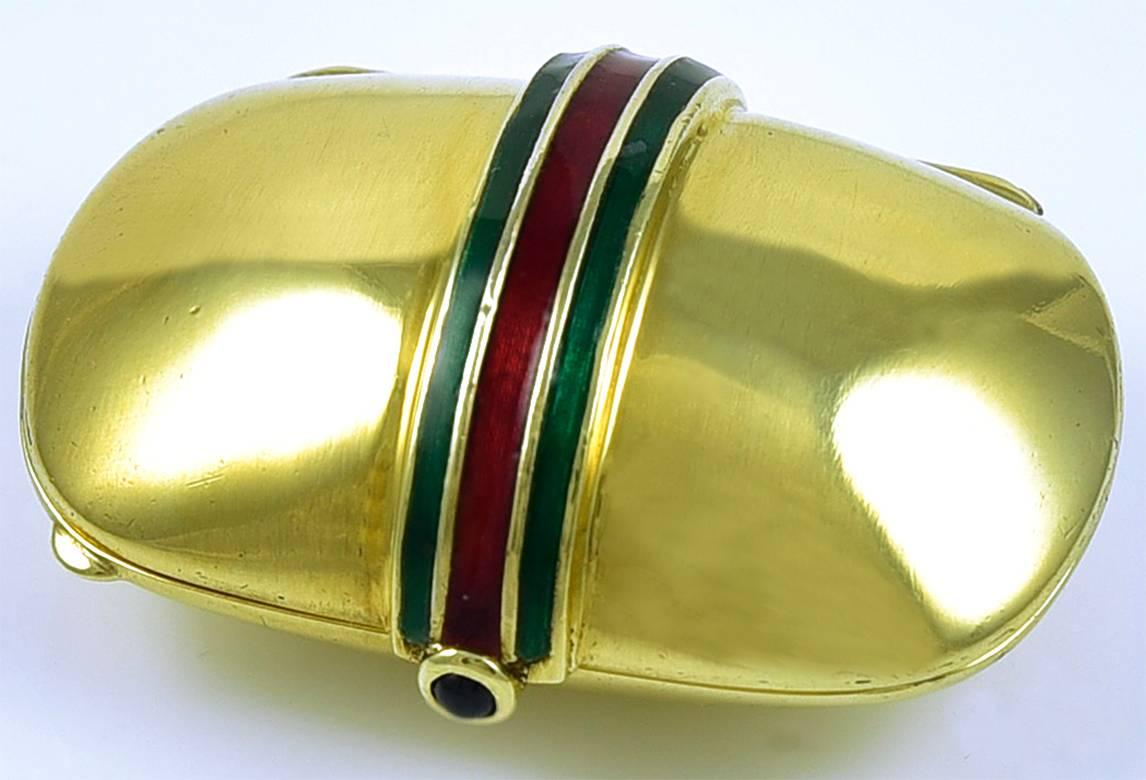 Most handsome hinged pill box.  Rich 18K yellow gold, with three applied green and red enamel stripes.  Cabochon sapphire closure.  1 1/8