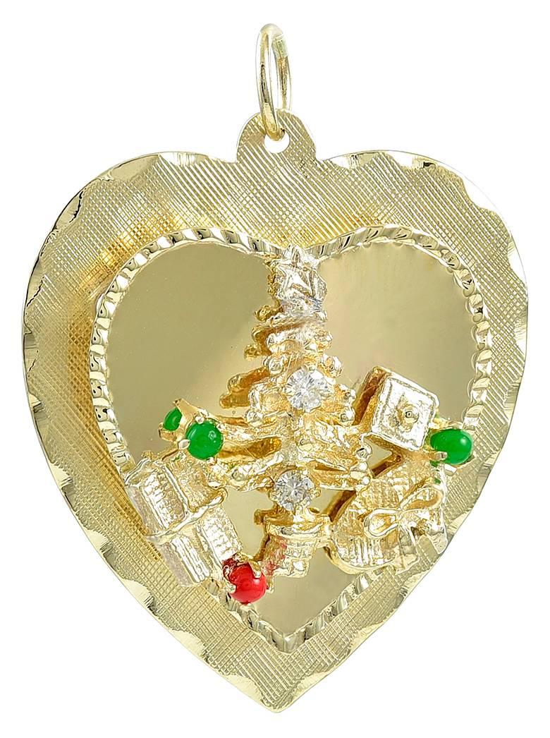 A figural heart-shaped charm, with an applied Christmas Tree and presents under the tree.  Set with a diamond, citrine, coral and jade.  Three-dimensional.  
1 1/4