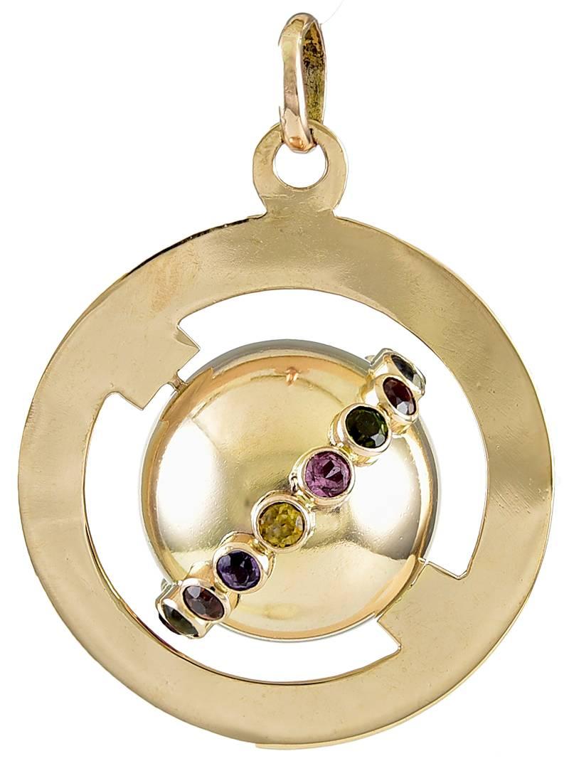 Large figural "Around The World" charm.  The outside border holds a spinning globe, set with amethysts, tourmalines, citrines and  topaz, that circle the entire earth.  1 1/4"in diameter.  A beautiful  and significant charm for the
