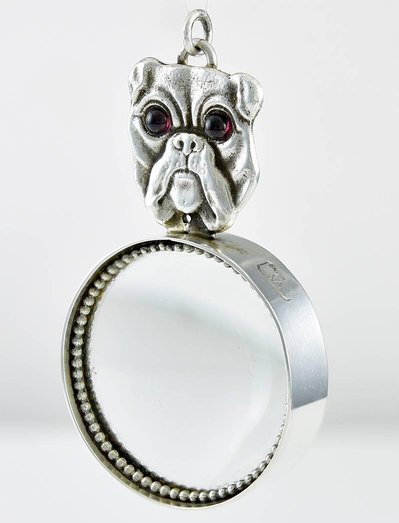 Antique figural English Bulldog Head magnifier pendant.  Sterling silver with garnet eyes.  Set on a sterling silver magnifier.   The pendant 2" long; the magnifier is 1 1/4" in diameter.  

Alice Kwartler has sold the finest antique