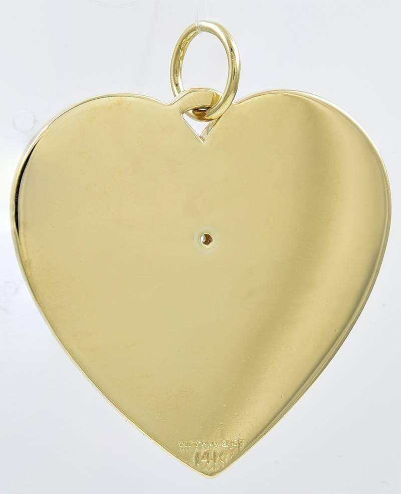 Gorgeous figural "Heart" charm/pendant.  Made and signed by Tiffany & CO.  Deep radiating line pattern, with an applied center flower comprised of six faceted sapphires and a diamond.  Very heavy gauge 14K yellow gold (29  grams).  1