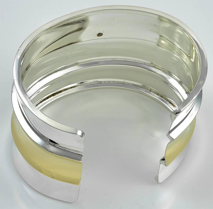 Sleek geometric cuff bracelet.   Made and signed by CARTIER.  Comprised of three sterling silver horizontal tiers, with an applied raised center tier in 18K yellow gold.   2 7/8" wide.  Fits a small to medium wrist.  Bold and beautiful.  A