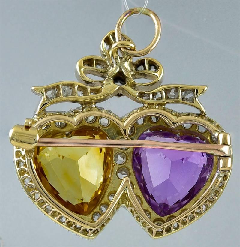 Absolutely beautiful antique pin:  two interlocking hearts, set in diamond frames with a diamond bow on top.  The hearts are made of brilliant faceted stones, one an amethyst and the other a citrine.  Sterling silver over 14K yellow gold.  Has a