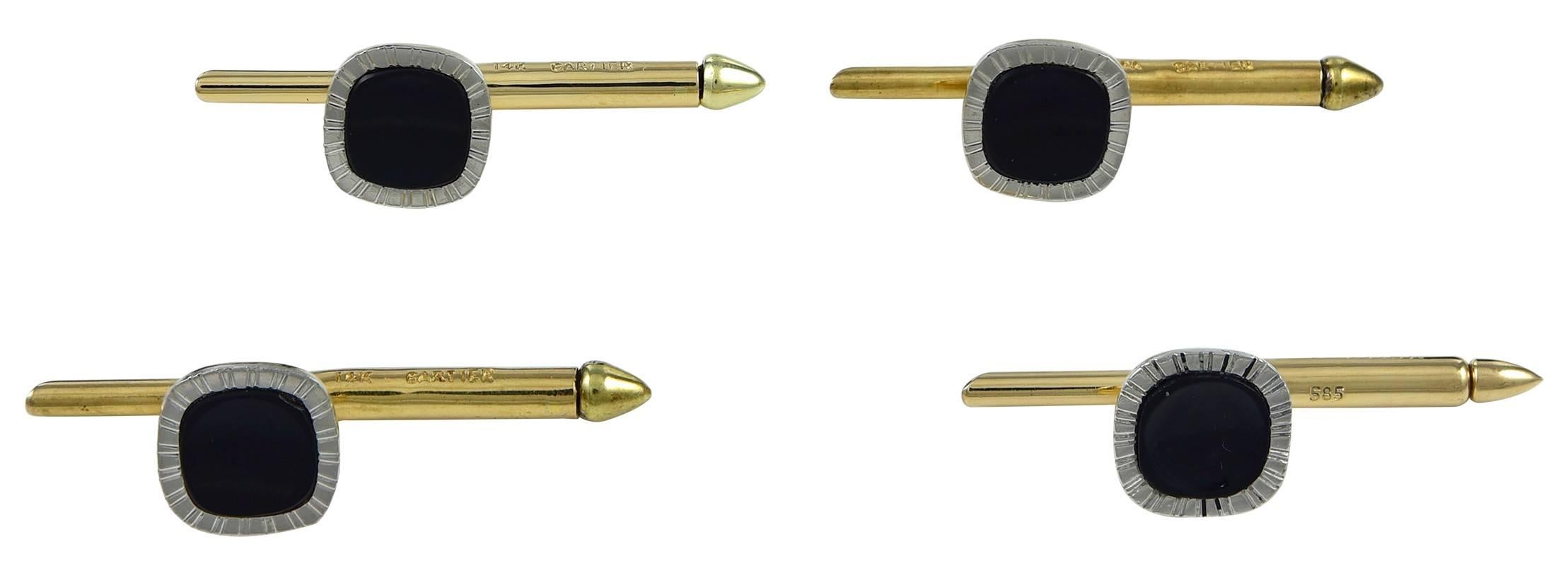 Handsome stud set, with two double-sided cufflinks and four matching studs.  Made, signed and numbered by CARTIER.  Polished black onyx, with a platinum border that has a carved art deco line pattern.  The backs and connectors are 14K yellow gold. 
