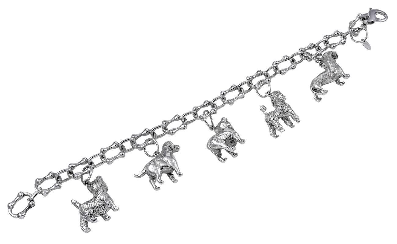 Spectacular sterling silver dog charm bracelet.  Made and signed by TIFFANY & CO.  Set with five exceptional figural charms in solid silver:  a dachshund, a poodle, a bull dog, a cocker spaniel and a westie.  The links on the bracelet are