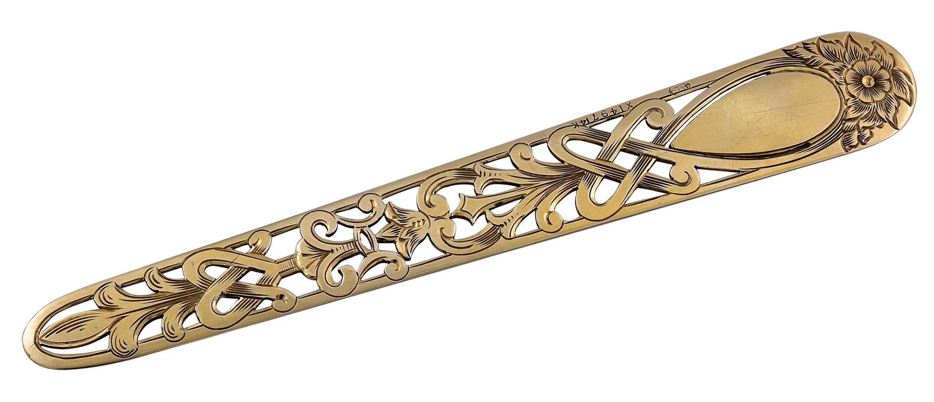Large antique book mark.  14K yellow gold.  Engraved floral cartouche at top; there is a space for a monogram; the rest is a reticulated intricately-cut leaf pattern.  3 7/8" long.  Pristine.  A beautifully detailed piece.

Aiice Kwartler has
