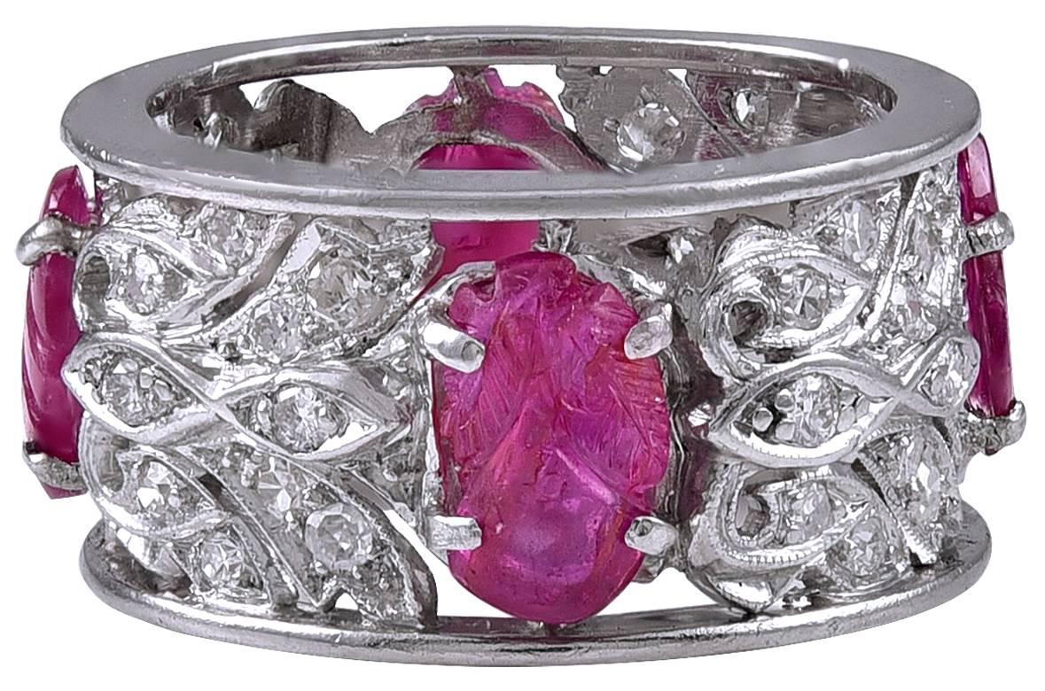 Einzigartiger und schöner Ring mit breitem Band.  Schimmernde Diamanten in einem komplizierten netzartigen Muster, besetzt mit vier geschnitzten Rubinen.  Platin.  1/3