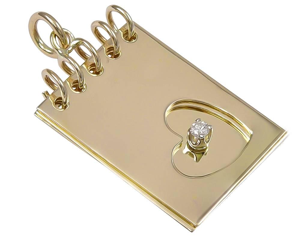 
Figural "Notepad" with spiral-bound top.  The top two pages have an open heart cut-out.  A secret message on the second page says "I Love You."  On the third page , there is a prong-set diamond that sits in the center of the