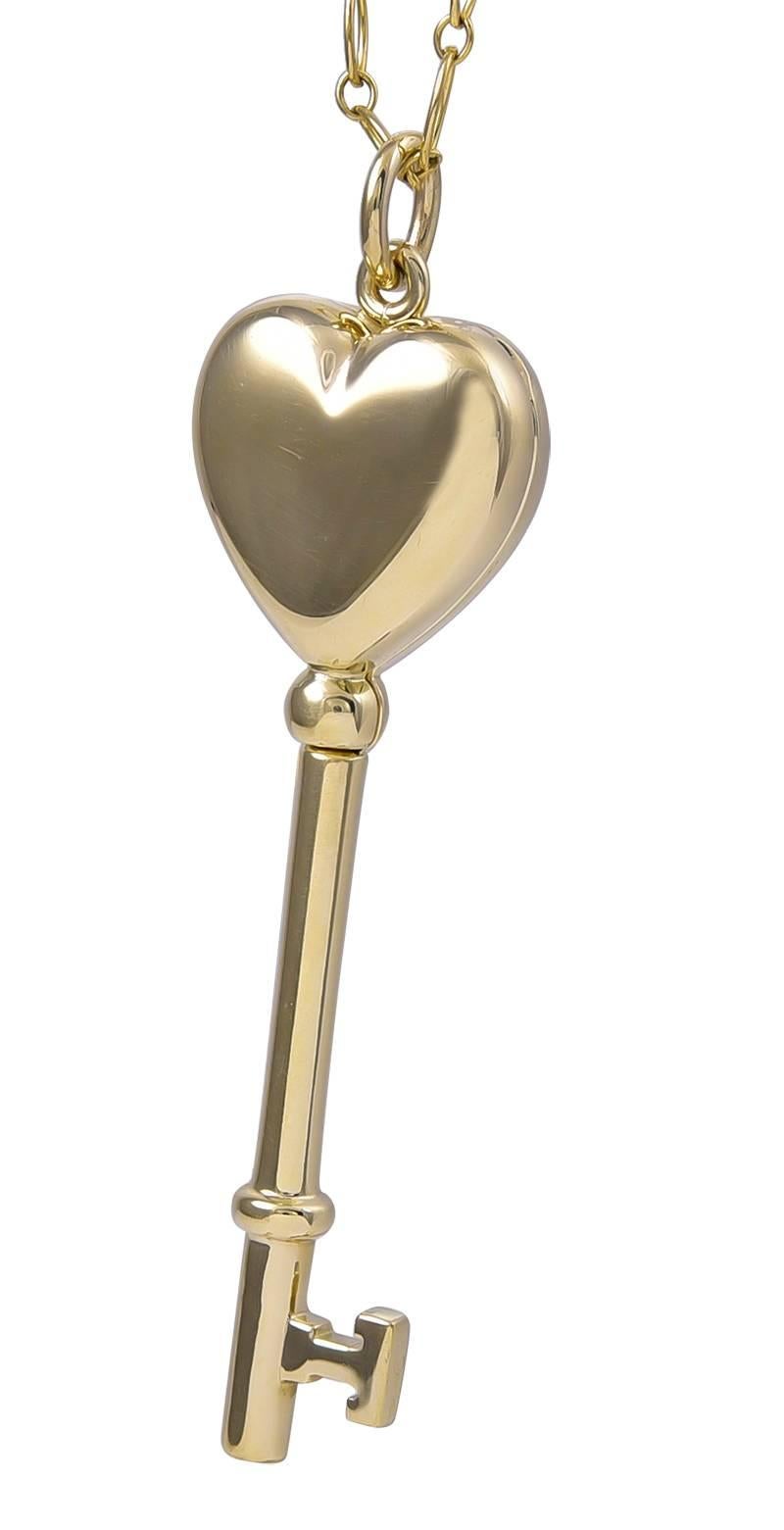 Rare "Key To My Heart" locket pendant.  Made and signed by TIFFANY & CO.  A figural "key" with a heart on top that opens into a locket for two pictures.  14K yellow gold.  On a 20" 18K gold TIFFANY chain.

Alice Kwartler