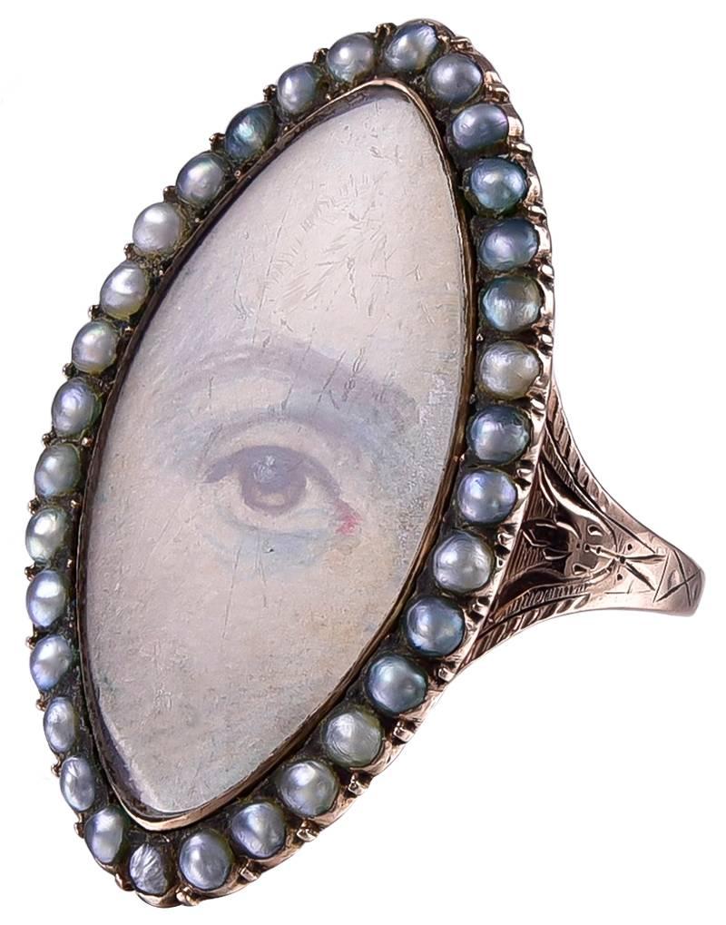Antique navette-shaped rose gold ring.  Very fine hand-painted miniature of an eye, surrounded by natural seed pearls.  Inscription and date (1787) on reverse side.  Size Size 6 and can be custom-sized.   9K rose gold.  An exquisite example.

Alice