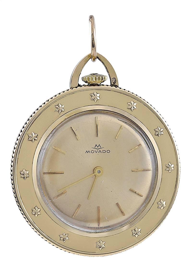 Well-detailed St. Christopher's Medal, set with a Movado watch.  14K yellow gold.  The watch is Swiss made, manual wind, with a coin edge.  There is an applied star motif around the bezel.  1 1/4" in diameter.  Made circa 1960.  A very special