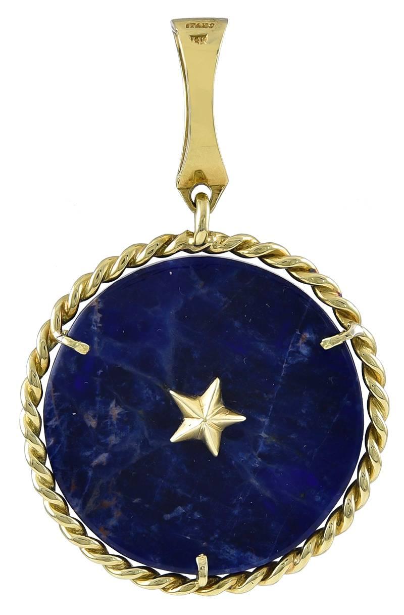 Large circular charm.  The center is lapis lazuli, with a rope edge border.  Applied in the center is a proud lion.  A three-dimensional star is applied on the reverse side.  1 1/2