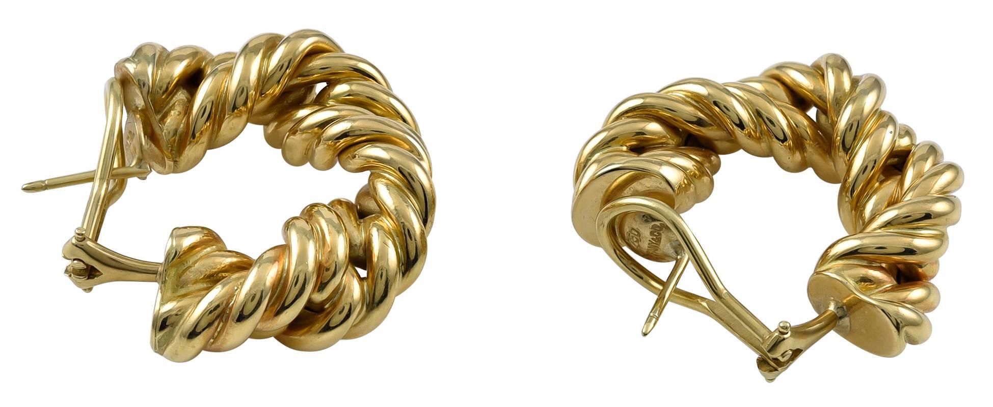 Unusual substantial rope twist earrings.  Made and signed by TIFFANY & CO.   Heavy gauge 18K yellow gold.  Very three-dimensional.  1 18" x 1 1/8" Omega clip with a post.  Most attractive.  An original rendering of a classic hoop