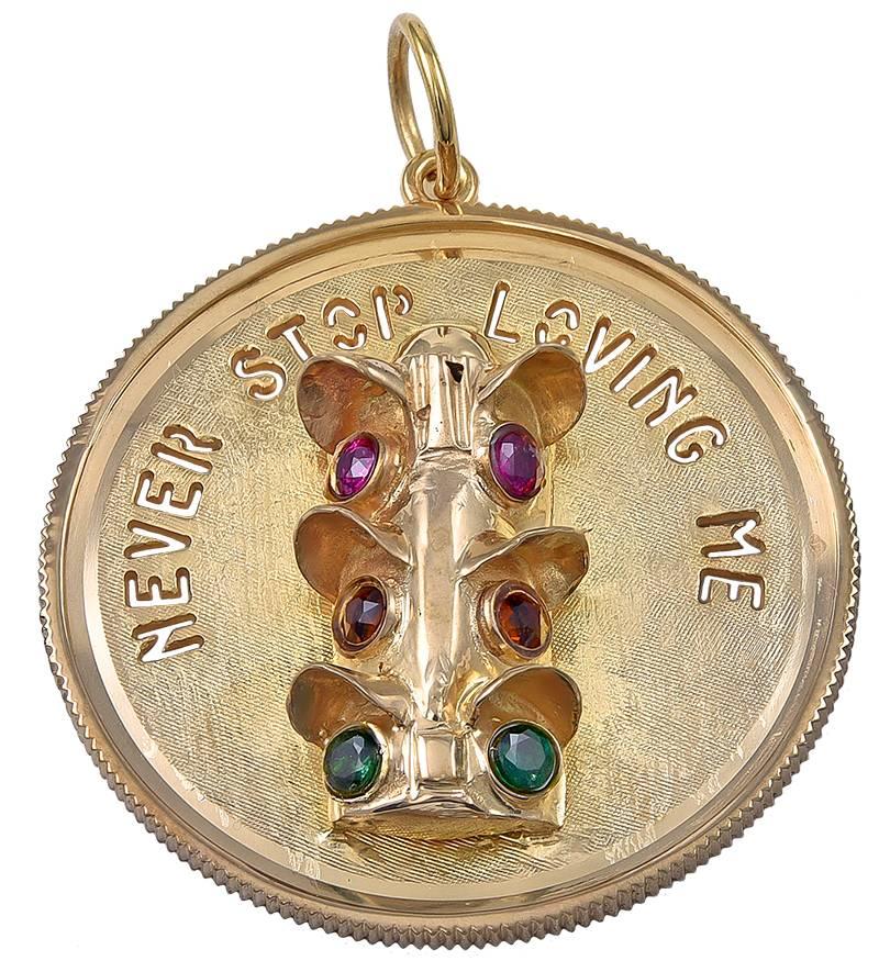 Large round charm.  Textured gold background, with cut-out letters spelling out "NEVER STOP LOVING YOU."  In the center is an applied figural "stoplight" set with rubies, amethysts and tourmalines.  1 1/2" in diameter.  Coin