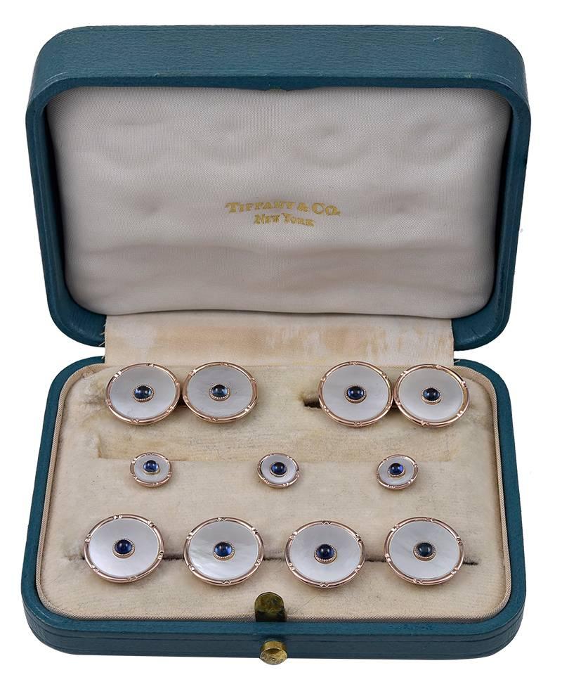 Antique men's dress set.  Made and signed by TIFFANY & CO.  14K yellow gold, with mother-of-pearl centers. Applied cabochon sapphire in middle of each piece.  A classic 9-piece set: two double-sided cufflinks,  four vest buttons and three studs.  In
