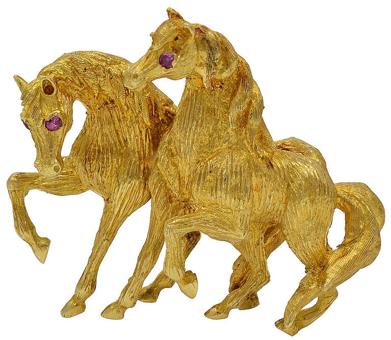 Pair of playful 18K gold frolicking horses with brilliant ruby eyes. Well detailed and proportioned.